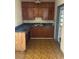 Modest kitchen featuring wood cabinets, laminate countertops, and a single basin sink at 411 Keat Ave, Auburndale, FL 33823