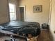 Dilapidated bedroom with covered bed and visible dog, requires extensive work at 445 Choctaw Ave, Lakeland, FL 33815