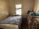 Bedroom showing a bed, dresser, and window, with signs of wear and tear at 445 Choctaw Ave, Lakeland, FL 33815