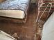 Bedroom with damaged wooden floors, a bed and personal items needing cleaning at 445 Choctaw Ave, Lakeland, FL 33815