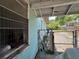 Side view of a light blue house with a chain-link fence, in disrepair at 445 Choctaw Ave, Lakeland, FL 33815