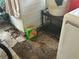 Damaged laundry room with broken tile floor and old appliances needing repair at 445 Choctaw Ave, Lakeland, FL 33815