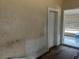 Unfinished living room corner showcases damaged walls and original wood floors at 445 Choctaw Ave, Lakeland, FL 33815