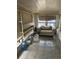 Enclosed porch featuring tile floors, multiple windows, and weathered furniture at 445 Choctaw Ave, Lakeland, FL 33815
