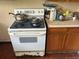Shows the stove, cluttered countertop, and deteriorated cabinets at 445 Choctaw Ave, Lakeland, FL 33815