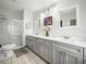 Bright bathroom featuring double sinks with white marble countertops and shower with glass door at 5027 Forest Crest Dr, Lakeland, FL 33810