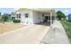 Side view of a well-maintained home featuring a long driveway and covered carport at 5027 Forest Crest Dr, Lakeland, FL 33810