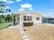 Quaint single-story home with a covered carport and pathway through a rock garden and lush landscaping at 5027 Forest Crest Dr, Lakeland, FL 33810