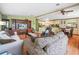Open-concept living room featuring hardwood floors, beamed ceilings, and views into the kitchen and dining areas at 5027 Forest Crest Dr, Lakeland, FL 33810