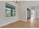 Dining room with hardwood floors, white walls, dark window trim and modern chandelier lighting at 5374 Clubhouse Hills Ln, Lakeland, FL 33812