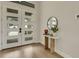 Bright entryway featuring a modern white door with glass panes and a stylish table with decor at 5374 Clubhouse Hills Ln, Lakeland, FL 33812