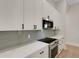 Modern kitchen featuring white cabinets, stainless steel appliances, gray backsplash, and sleek black hardware at 5374 Clubhouse Hills Ln, Lakeland, FL 33812