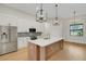 Open kitchen features a large island, stainless steel appliances, and modern pendant lighting at 5374 Clubhouse Hills Ln, Lakeland, FL 33812