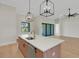 Bright kitchen island with a white countertop, wooden cabinets, modern lighting, and stainless steel appliances at 5374 Clubhouse Hills Ln, Lakeland, FL 33812