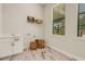 Bright laundry room with sink, white cabinets, shelving, and a window for natural light at 5374 Clubhouse Hills Ln, Lakeland, FL 33812