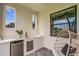 Outdoor bar area features a mini-fridge, sink, countertops, and hanging chair near large windows at 5374 Clubhouse Hills Ln, Lakeland, FL 33812