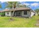 A spacious, grassy backyard featuring a screen porch and mature palm tree at 628 Wexford Ct, Winter Haven, FL 33884
