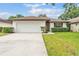 Charming single-story home featuring a two-car garage, manicured lawn, and mature landscaping at 628 Wexford Ct, Winter Haven, FL 33884