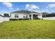 Well-maintained backyard with lush grass, a white fence, and a view of the home's back exterior at 6627 Ridgemont Rd, Lakeland, FL 33813