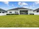 Lush green backyard framed by a white fence, with a covered patio and a view of the home's exterior at 6627 Ridgemont Rd, Lakeland, FL 33813