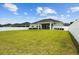 Grassy backyard framed by a white fence, showcasing the home's exterior and spacious outdoor area at 6627 Ridgemont Rd, Lakeland, FL 33813