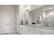 Bright bathroom featuring double vanity with marble countertop, white cabinets, and large mirror at 6627 Ridgemont Rd, Lakeland, FL 33813