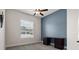 Bright bedroom showcasing a blue accent wall, ceiling fan, and a dark wooden desk beneath the window at 6627 Ridgemont Rd, Lakeland, FL 33813