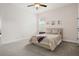 Cozy bedroom with neutral carpet, ceiling fan, window, and stylish decor at 6627 Ridgemont Rd, Lakeland, FL 33813