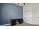 Bedroom with blue accent wall features neutral carpet and a functional dark wood desk at 6627 Ridgemont Rd, Lakeland, FL 33813