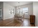 Light filled dining room with rustic wood floors, modern chandelier, and views from large windows at 6627 Ridgemont Rd, Lakeland, FL 33813