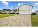 Spacious brick-paved driveway leading to a modern home with lush green landscaping at 6627 Ridgemont Rd, Lakeland, FL 33813