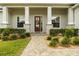 Inviting front entrance with stone pillars, lush landscaping, and a charming wood door at 6627 Ridgemont Rd, Lakeland, FL 33813
