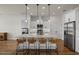 An island kitchen with stainless steel appliances, pendant lighting and bar stool seating at 6627 Ridgemont Rd, Lakeland, FL 33813