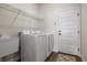 Well-lit laundry room with modern appliances, utility sink, wire shelving and a closed door at 6627 Ridgemont Rd, Lakeland, FL 33813