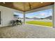 View of a covered patio with stone pavers, a ceiling fan, and outdoor furniture overlooking the backyard at 6627 Ridgemont Rd, Lakeland, FL 33813