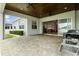 Back patio with wood ceiling, ceiling fans, and exterior kitchen overlooking lush grass backyard at 6627 Ridgemont Rd, Lakeland, FL 33813