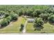 Expansive aerial view of the property featuring a home, surrounding land, and wooded areas at 7011 Tall Pine Rd, Polk City, FL 33868