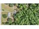 Top-down aerial view of a home, outbuildings, driveway, lush surrounding trees, and adjacent road at 7011 Tall Pine Rd, Polk City, FL 33868