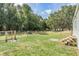 Fenced backyard with a grassy area, featuring wooden steps to the side door at 7011 Tall Pine Rd, Polk City, FL 33868