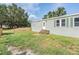 Backyard features a green lawn and a house with a small porch at 7011 Tall Pine Rd, Polk City, FL 33868