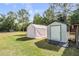 Backyard featuring two sheds on a green lawn at 7011 Tall Pine Rd, Polk City, FL 33868