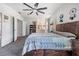 Spacious bedroom with a bed, ceiling fan, and a glimpse into an en-suite bathroom at 7011 Tall Pine Rd, Polk City, FL 33868