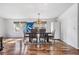 Cozy dining room with a rustic wood table, stylish lighting, and natural light at 7011 Tall Pine Rd, Polk City, FL 33868