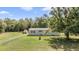 Charming single-story home with lush green lawn and mature trees offering a serene and private setting at 7011 Tall Pine Rd, Polk City, FL 33868
