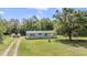 A quaint single story home with a long driveway situated on a lush green lot at 7011 Tall Pine Rd, Polk City, FL 33868