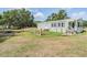 Inviting home exterior featuring a covered porch, green shutters, and a spacious yard at 7011 Tall Pine Rd, Polk City, FL 33868