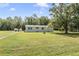 A single story home with green shutters, resting on a beautiful green lot at 7011 Tall Pine Rd, Polk City, FL 33868