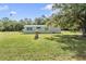 Charming single-story home with a well-maintained lawn and beautiful surrounding trees, offering a serene and inviting atmosphere at 7011 Tall Pine Rd, Polk City, FL 33868