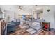 Bright living room featuring wood floors, a plush gray sofa, and lots of natural light at 7011 Tall Pine Rd, Polk City, FL 33868
