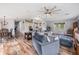 Open-concept living space featuring wood floors, a sectional sofa, and seamless flow to the dining area at 7011 Tall Pine Rd, Polk City, FL 33868